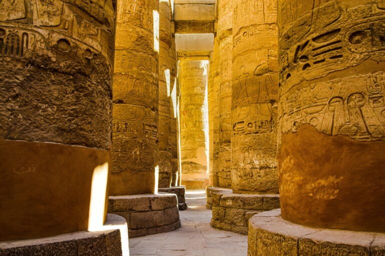 Sunlit ancient columns in the historic Karnak Temple Complex in Luxor, Egypt.