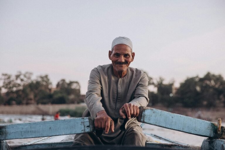 How to Spend one Day in Cairo? Elderly man enjoying a serene boat ride on the Nile in Al Qanatir, Egypt.